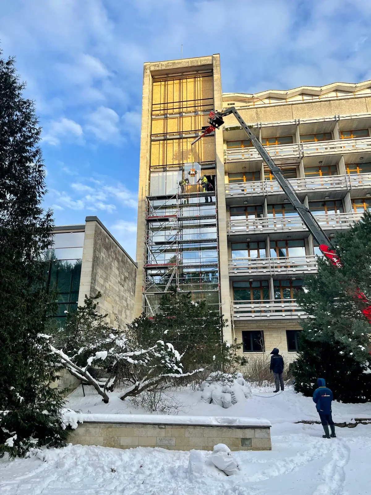 Façade work on a multi-storey building with lifting equipment and scaffolding